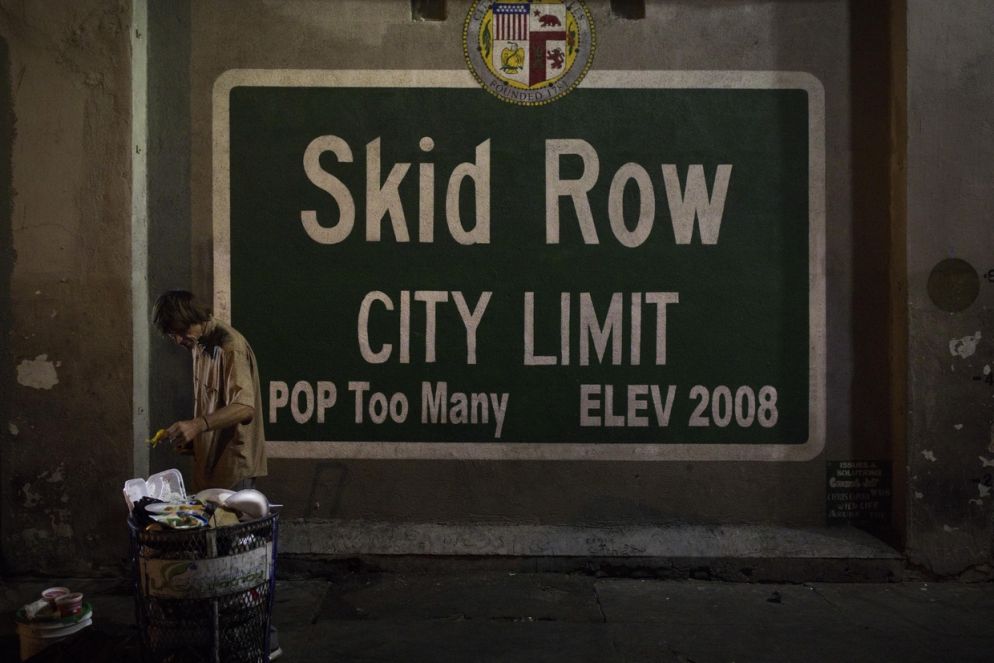 Un senzatetto in cerca di cibo da un cassonetto della spazzatura nella zona Skid Row di Los Angeles: nella metropoli il numero di homeless è cresciuto del 26 per cento (Ansa)