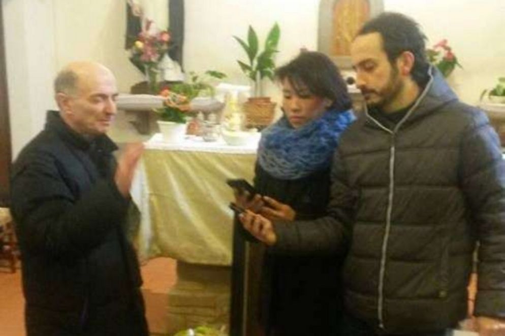 Don Giorgio Mariotti mentre benedice i cellulari lo scorso anno nella parrocchia di Nuvole