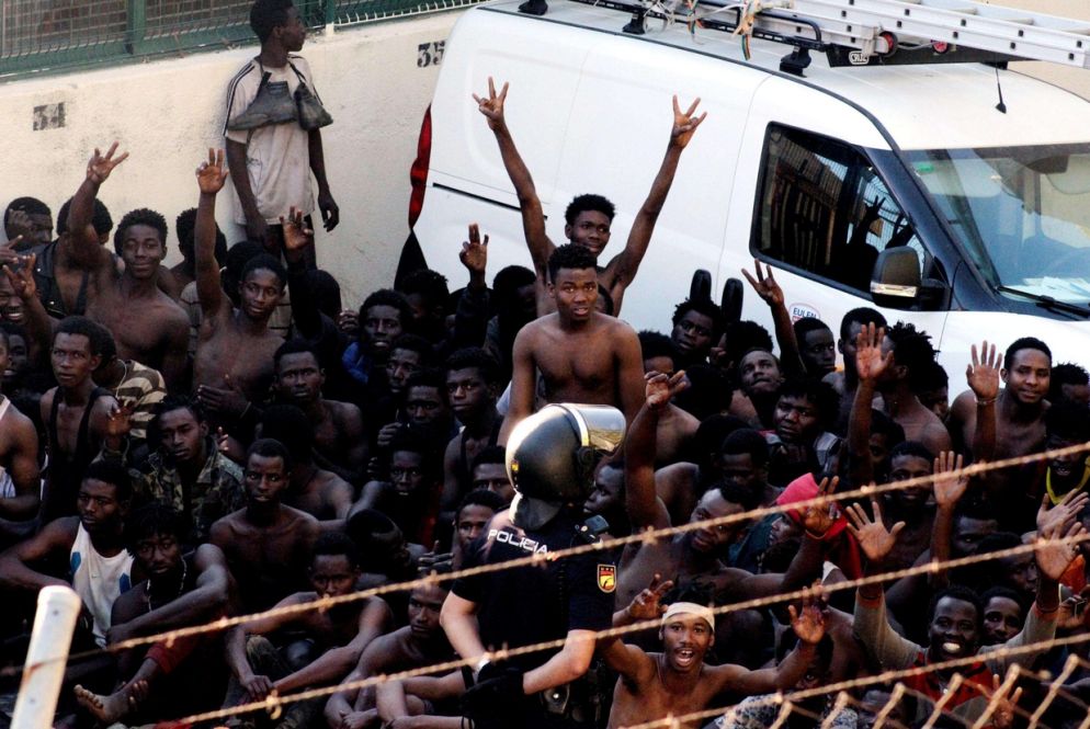 Il gesto di vittoria di chi è riuscito a superare la recinzione ed entrare a Ceuta (Ansa)