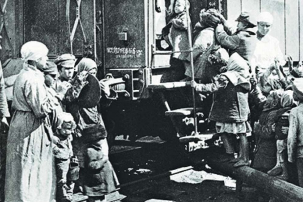 Bambini in fila per ricevere la razione di cibo da un treno dei soccorsi (1921)