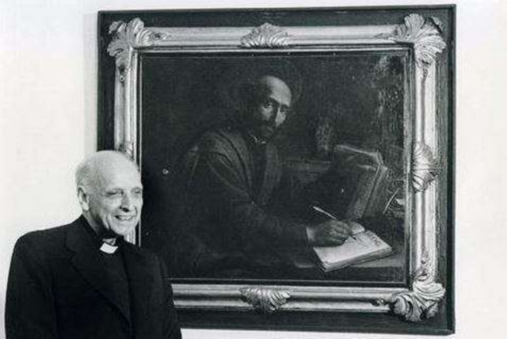 Padre Arrupe all'interno della Curia dei gesuiti a Roma ritratto accanto a un quadro raffigurante Ignazio di Loyola