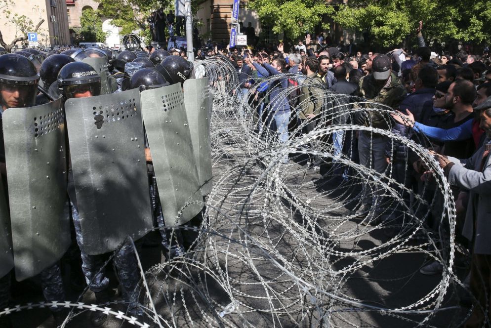 La polizia ferma i dimostranti che vogliono impedire l'accesso dei deputati al Parlamento (Ansa)