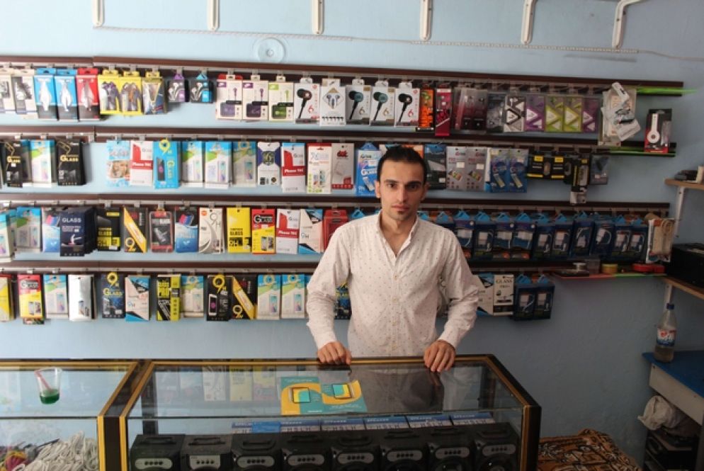 Imad Alde Nnkahal nel suo negozio di telefonia in Rue Superstar, Aleppo Est