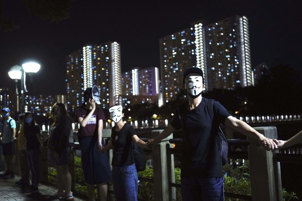 Una catena umana notturna nel cuore economico di Hong Kong (Ansa)