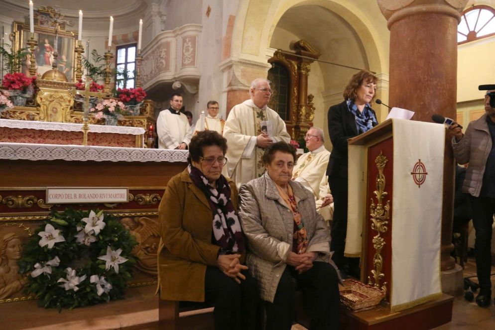 Il discorso di Meris Corghi, figlia di uno dei due partigiani che assassinarono il giovane seminarista. Sedute, da sinistra: Maria moglie del fratello del beato, e Rosanna, sorella del martire