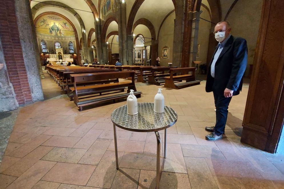 Don Magnani accoglie i fedeli con il gel per la prima Messa "pubblica" nella Basilica di San Babila a Milano - Avvenire