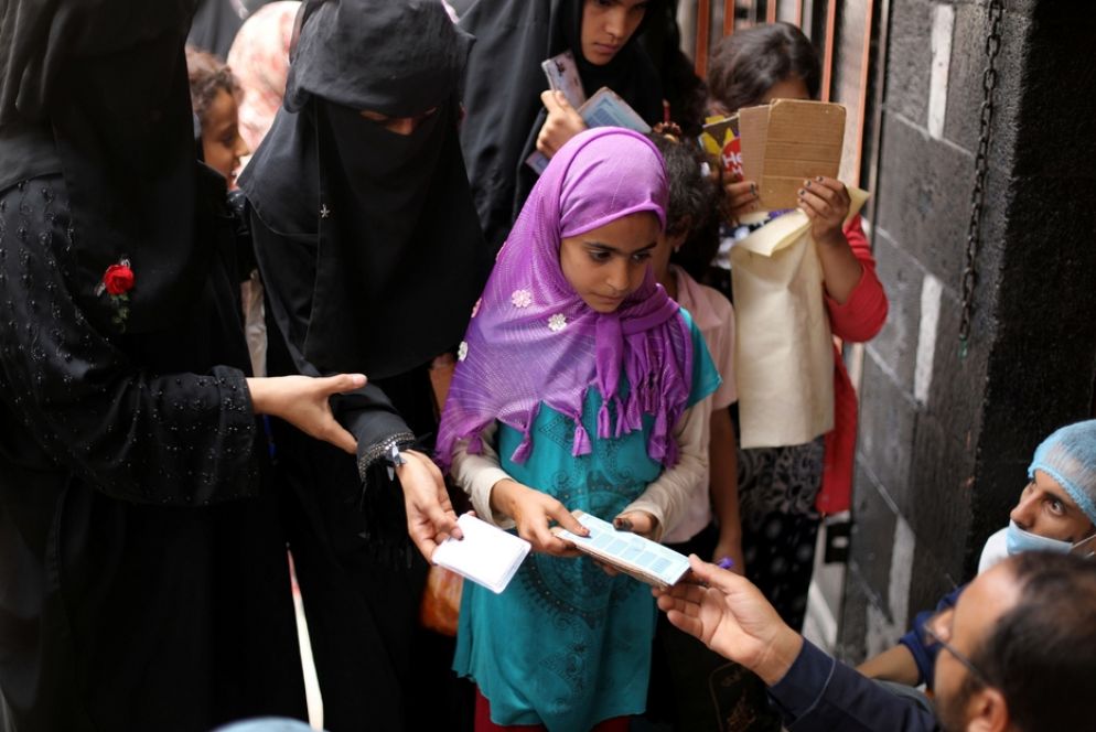 Una bambina riceve un buono alimentare a Sanaa (luglio 2020) - REUTERS/Khaled Abdullah