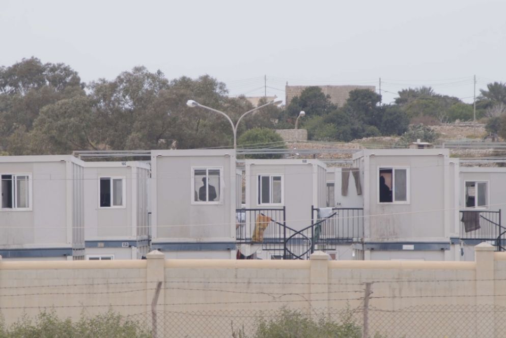 Il centro di ricezione di Hal Far dove vivono 1.000 migranti divisi fra i container della struttura ufficiale e gli edifici cadenti fra spazzatura e carcasse di automobili - Nunzio Gringeri