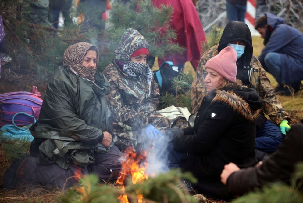 Migranti intorno al fuoco in attesa di tentare il passaggio dalla Bielorussia alla Polonia - Leonid Scheglov/BelTA/ via REUTERS