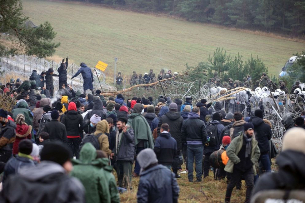 Un gruppo di migranti si raduna in attesa di passare dalla Bielorussia alla Polonia, nella regione di Grodno - Leonid Scheglov/BelTA/ via REUTERS
