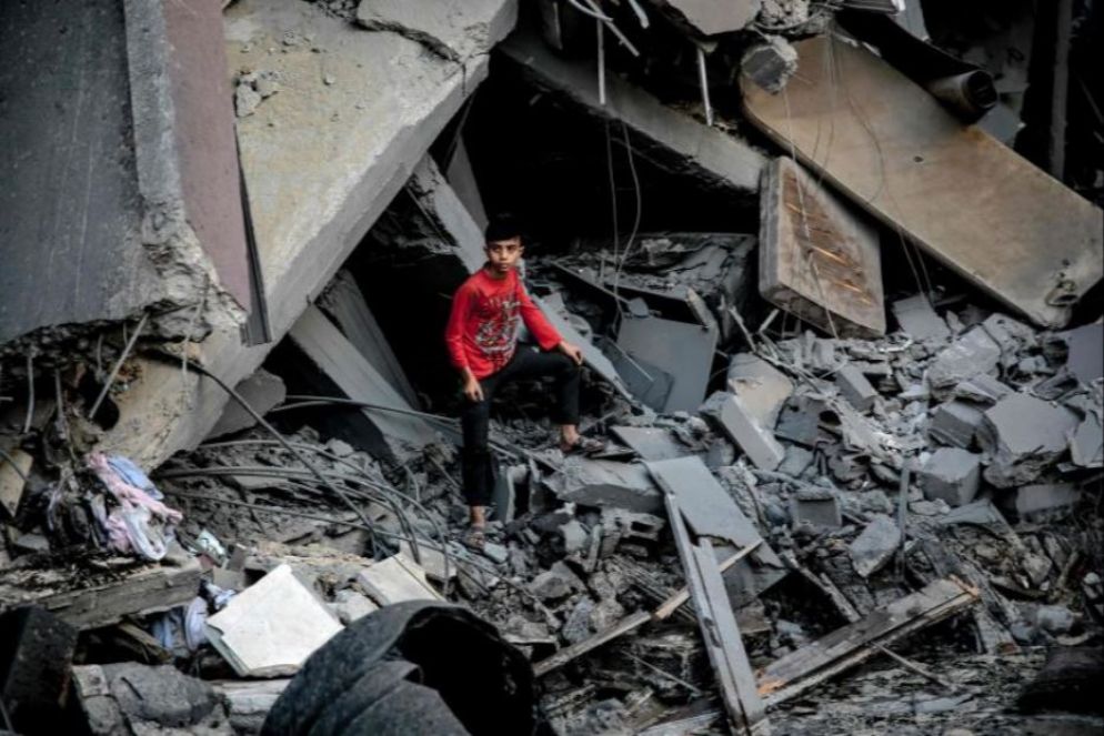 Un ragazzo palestinese tra le macerie di un edificio crollato dopo un attacco israeliano a Gaza - Ansa