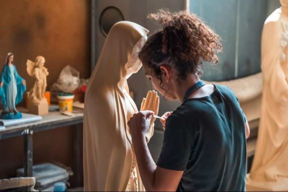 Un'artigiana al lavoro su una delle opera in vendita sul sito di Holyart - -