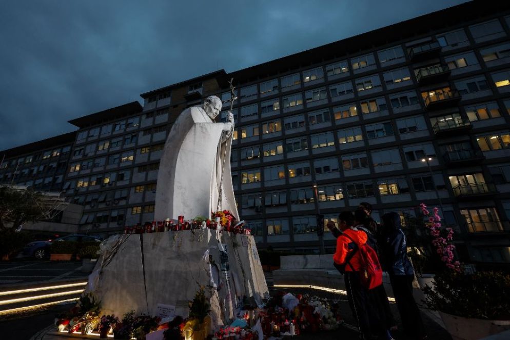La preghiera davanti alla statua di Giovanni Paolo II all'ingresso del Policlinico Gemelli a Roma dove papa Francesco è ricoverato - Ansa
