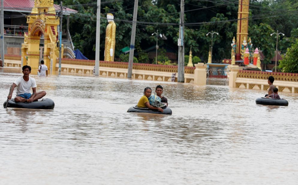 Gli abitanti di Taungoo, nella regione birmana di Bago, cercano di mettersi in salvo "navigando" le acque alluvionali sulle camere d'aria - ANSA