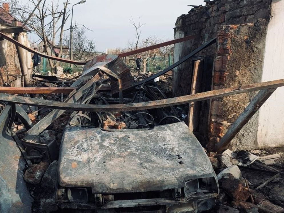 Un’auto distrutta dall’esplosione che ha devastato anche le abitazioni. I residenti erano corsi al riparo poco prima che i droni colpissero le loro case