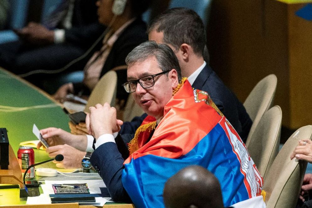 Il presidente serbo Vucic avvolto nella bandiera serba attende l'esito della votazione all'Onu - Reuters