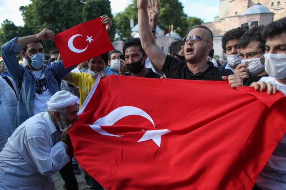 Un gruppo di musulmani a Istanbul con la bandiera turca - Ansa