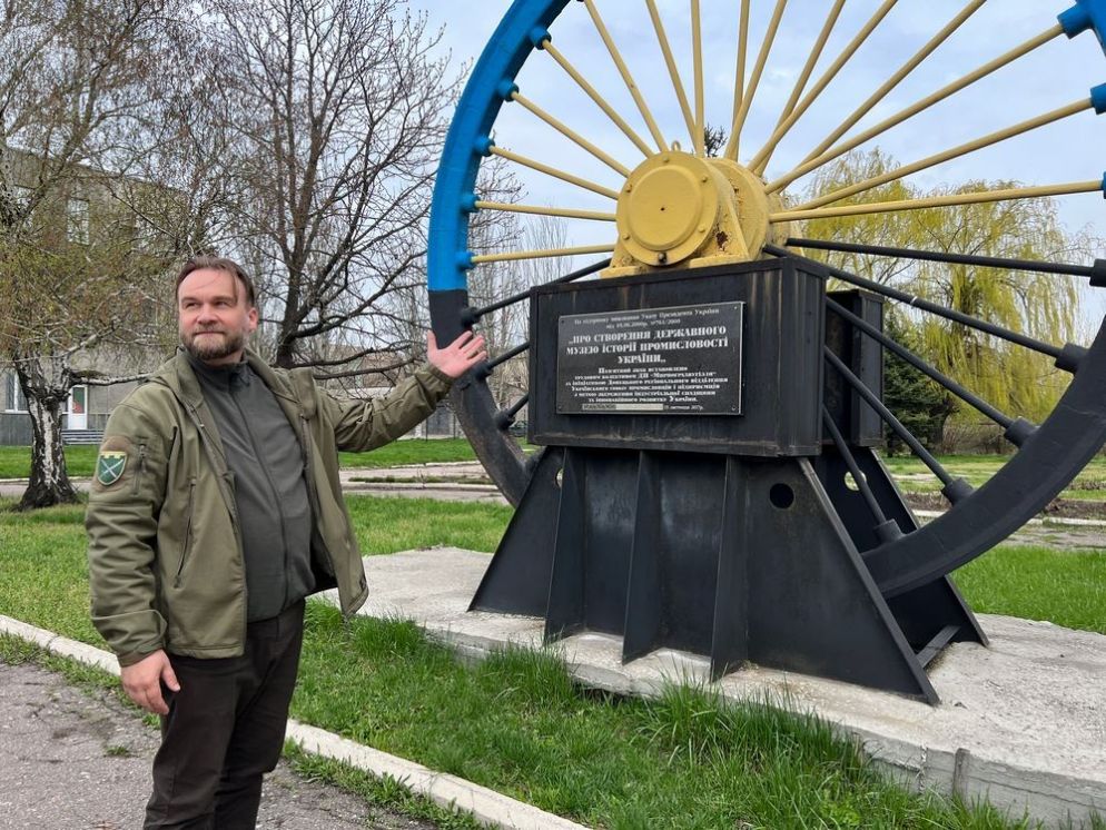 Padre Ivan Vasylenko davanti al simbolo della città di Myrnohrad - Gambassi