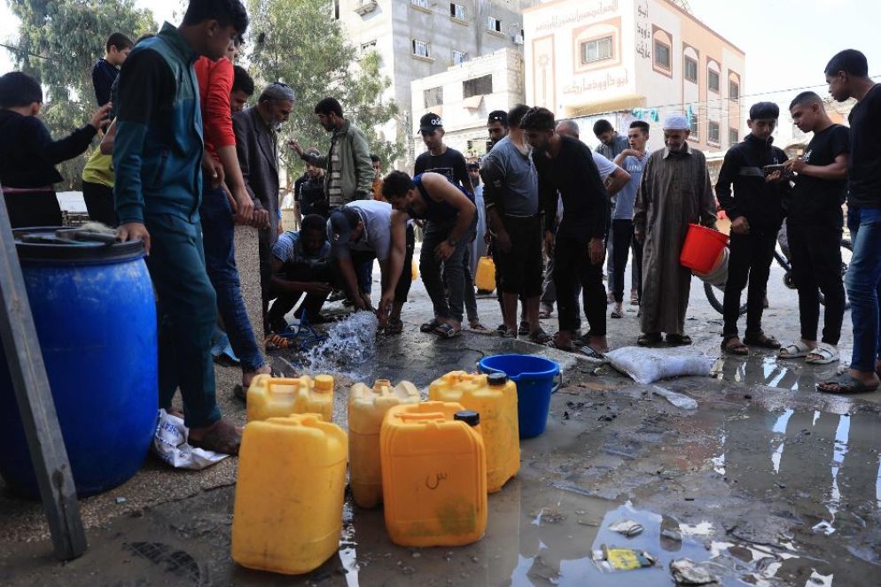 Abitanti di Rafah, nel Sud della Striscia di Gaza, in coda per riempire le loro taniche e i secchi con acqua dei pozzi usata per l’agricoltura - Ansa