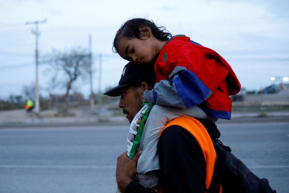 Padre con la bimba sulle spalle a Piedras Negras sul confine tra Messico e Usa - Reuters