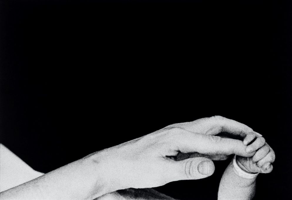In mostra a Forlì, Musei di San Domenico, "Eve Arnold. L’opera, 1950-1980": i primi cinque minuti di vita di un neonato. Una madre tiene la mano del suo piccolo. New York, Long Island, 1959 - © Eve Arnold / Magnum Photos
