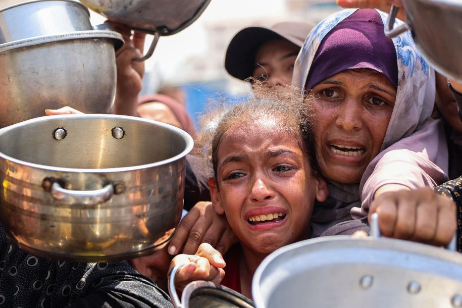 Una madre e sua figlia implorano cibo in fila a Gaza - Ansa