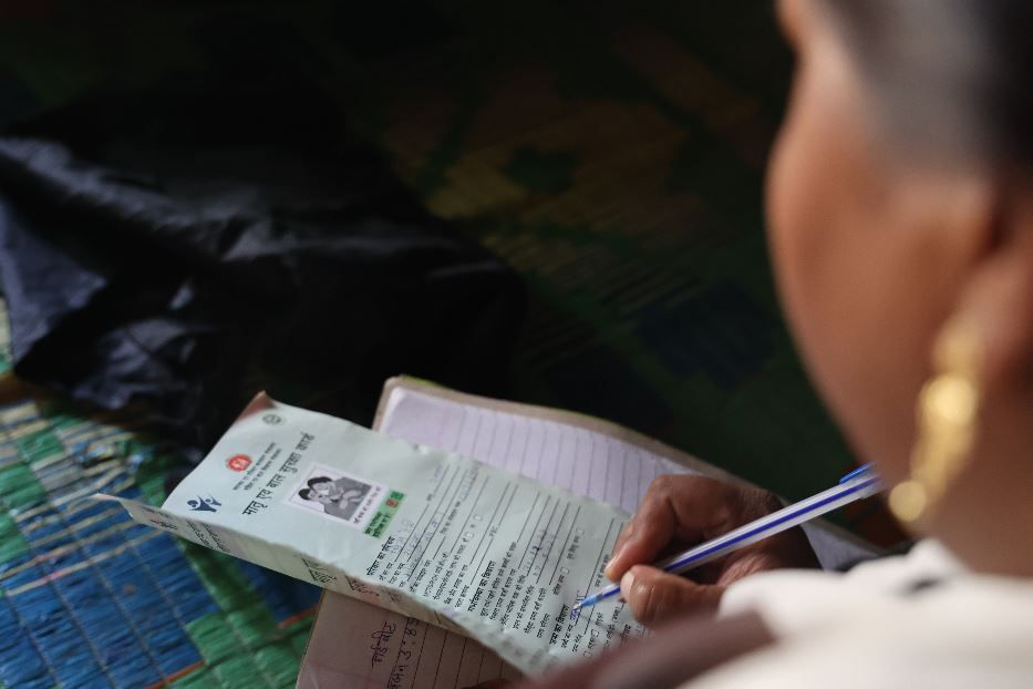 Una operatrice sociale compila il registro dopo una visita a un bambino - Sejal, Khabr Lahariya