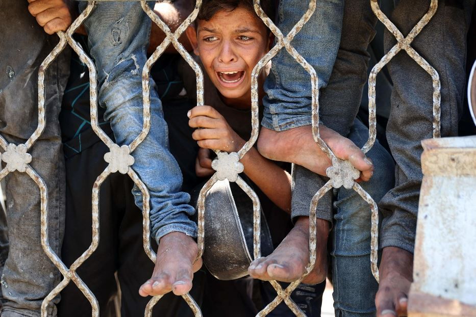 Un bambino disperato attende tra la folla il cibo - Ansa