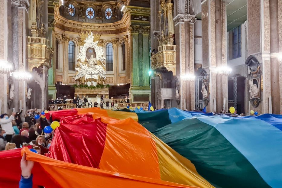 L'enorme bandiera coi colori della pace fatta sventolare durante una giornata di preghiera nel Duomo di Napoli - Ansa