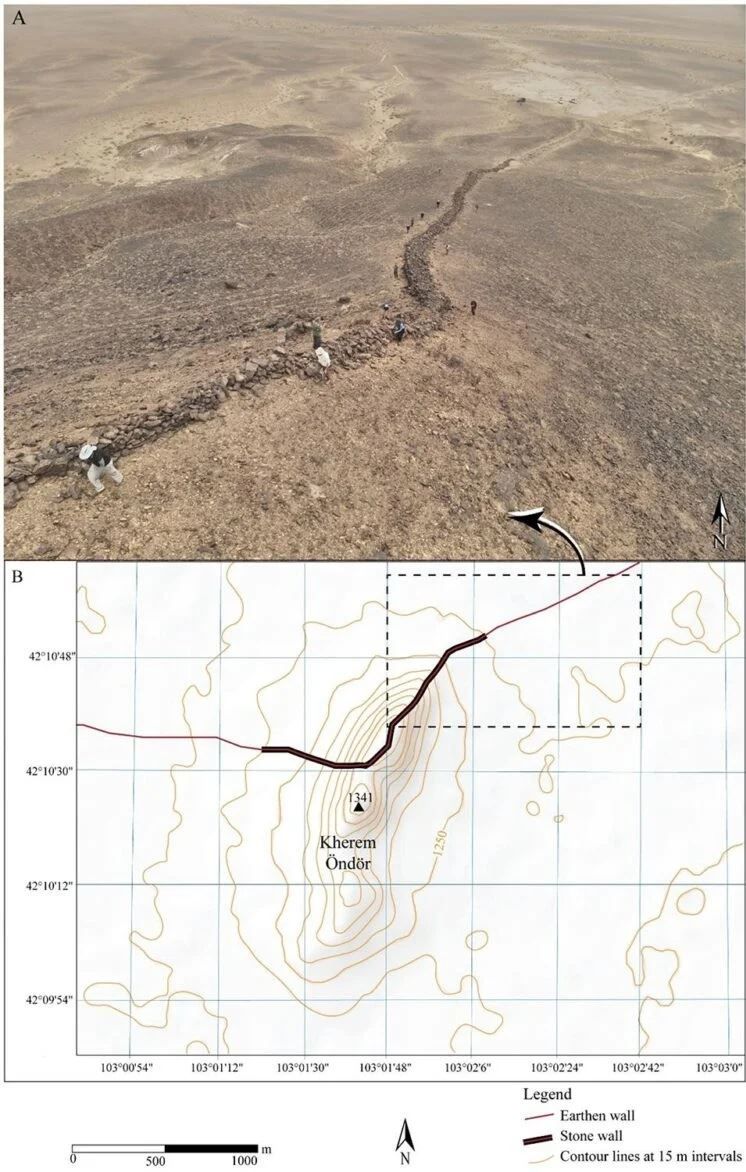 Fotografia aerea scattata da drone che mostra la sezione del muro in pietra conservata che attraversa il pendio (A). Mappa topografica che illustra la posizione strategica del muro sulla cima del Kherem Öndör, con segmenti differenziati di muro in terra (linea rossa) e in pietra (linea nera) (B) - D Golan et al., Land (2025)