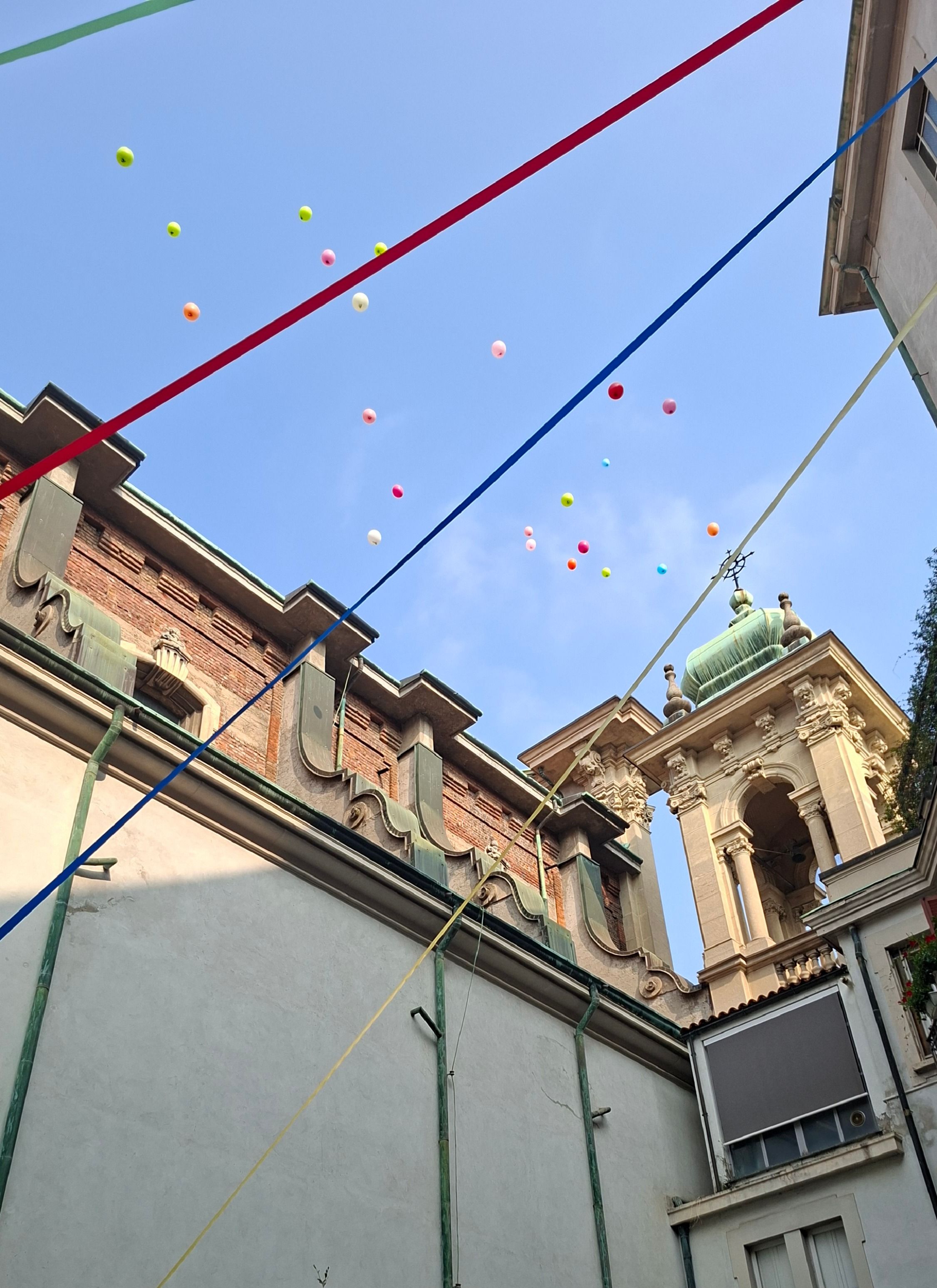 Lancio di palloncini nel cortile dal quale si accede all'oratorio di Santa Maria Segreta (della quale si scorge il campanile)