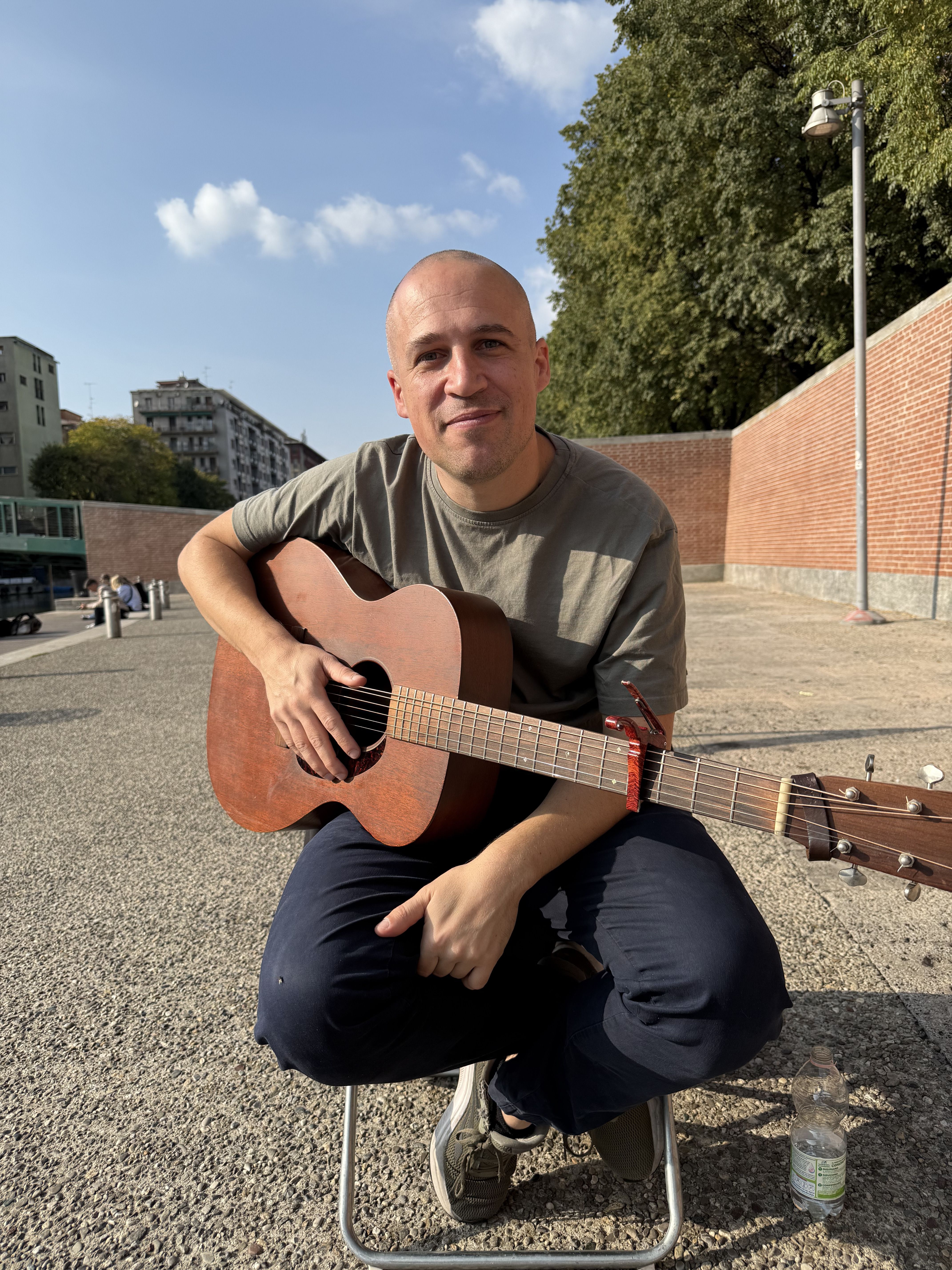 Il cantautore Marcello Ubertone con la sua chitarra, sulla Darsena di Milano