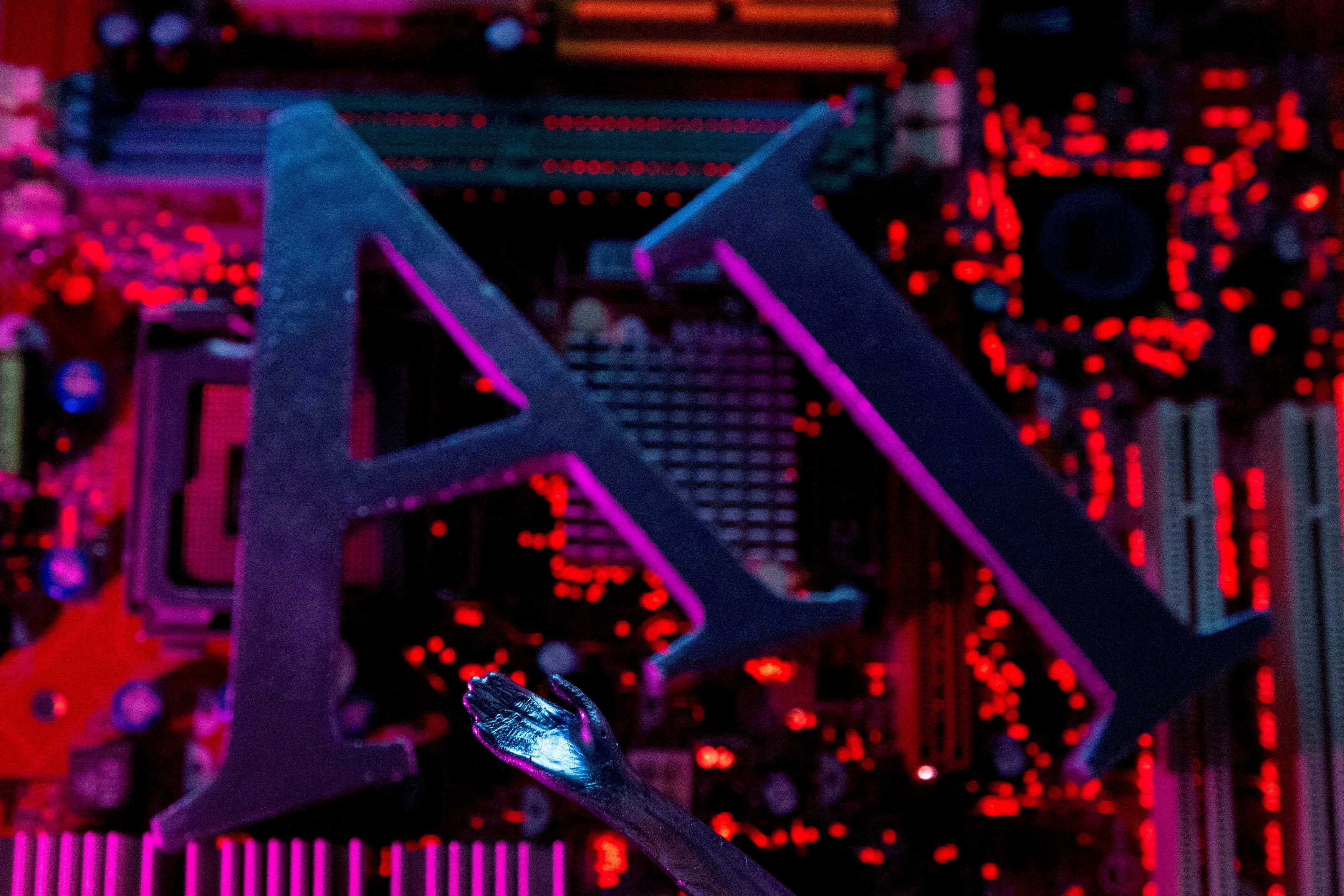 Le iniziali dell'Intelligenza artificiale davanti a una scheda madre di pc / Reuters