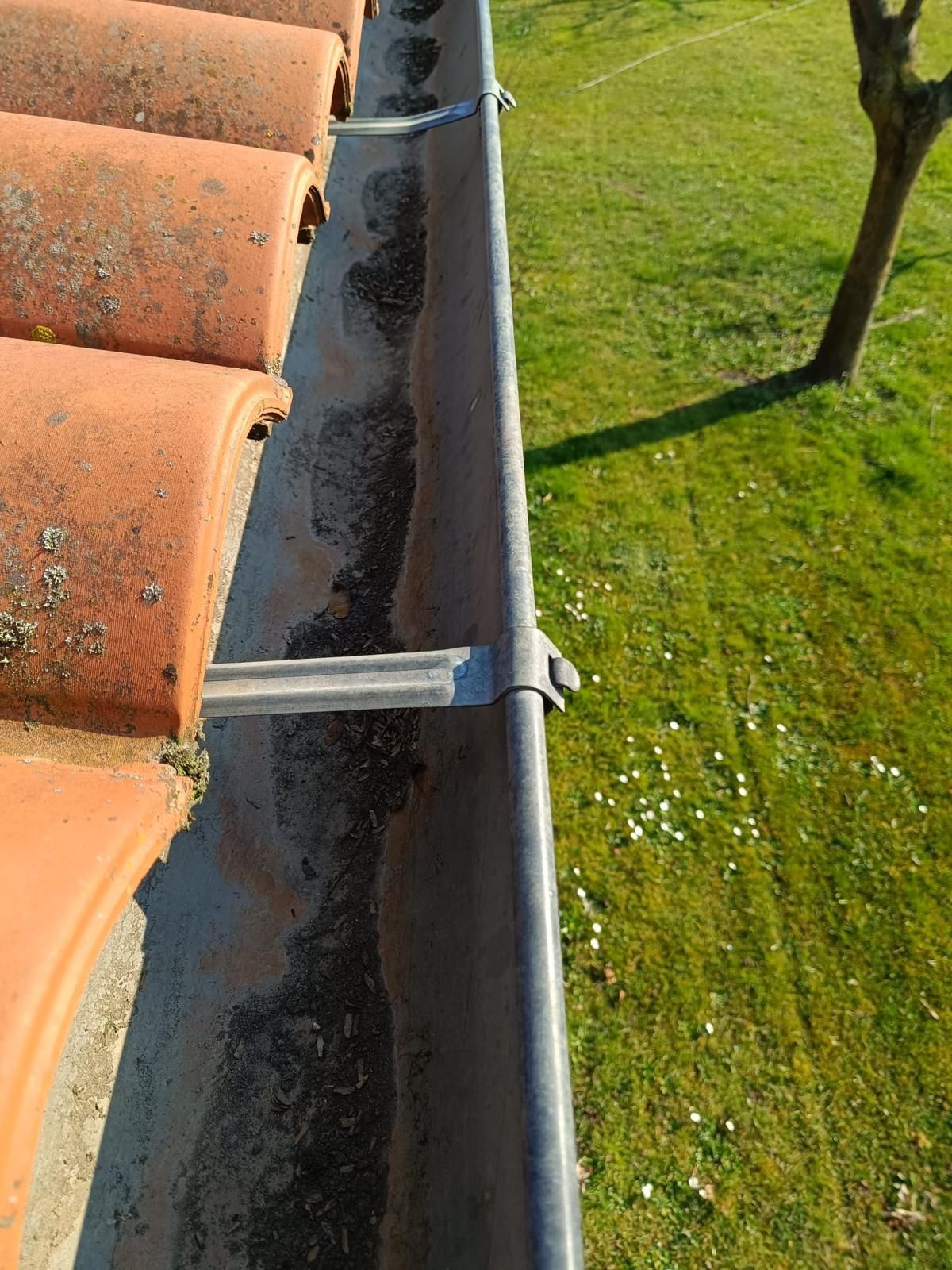 La polvere nera accumulata in una grondaia