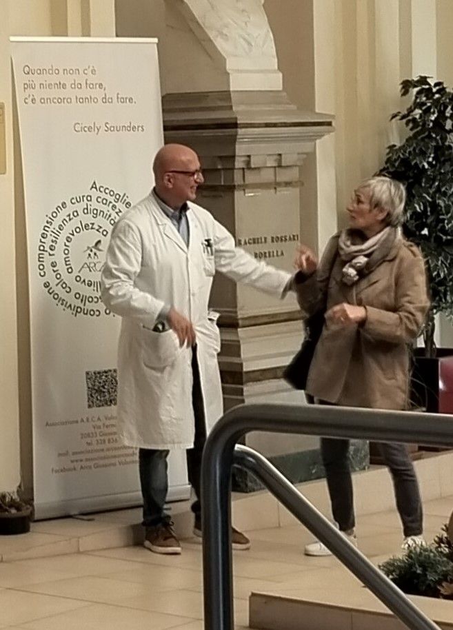 Il dottor Beretta accoglie una visitatrice, alle sue spalle una delle celebri frasi di Cicely Saunders