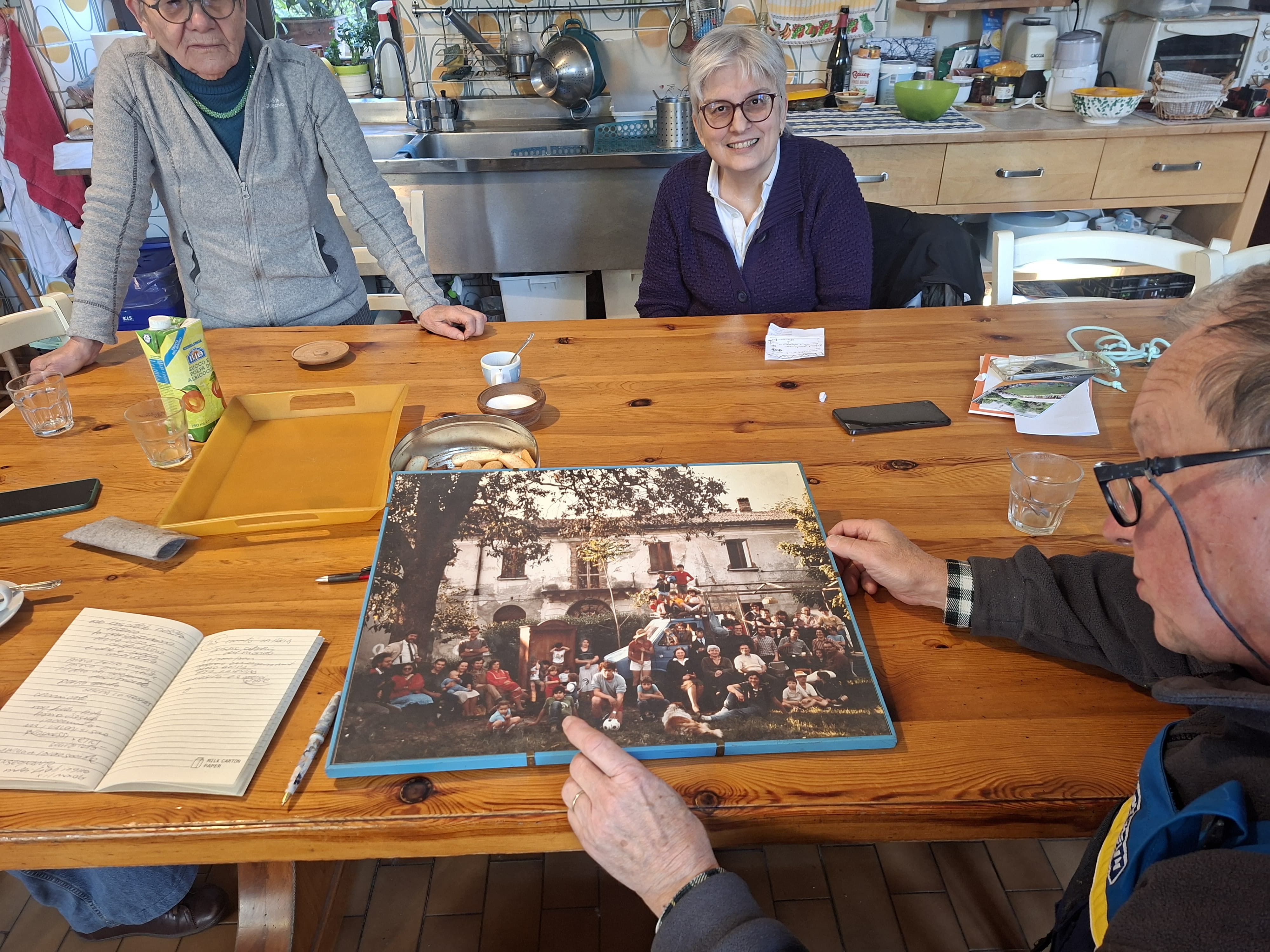 Massimo mostra una fotografia del primo gruppo di famiglie che si trasferì nella villa, nel 1978
