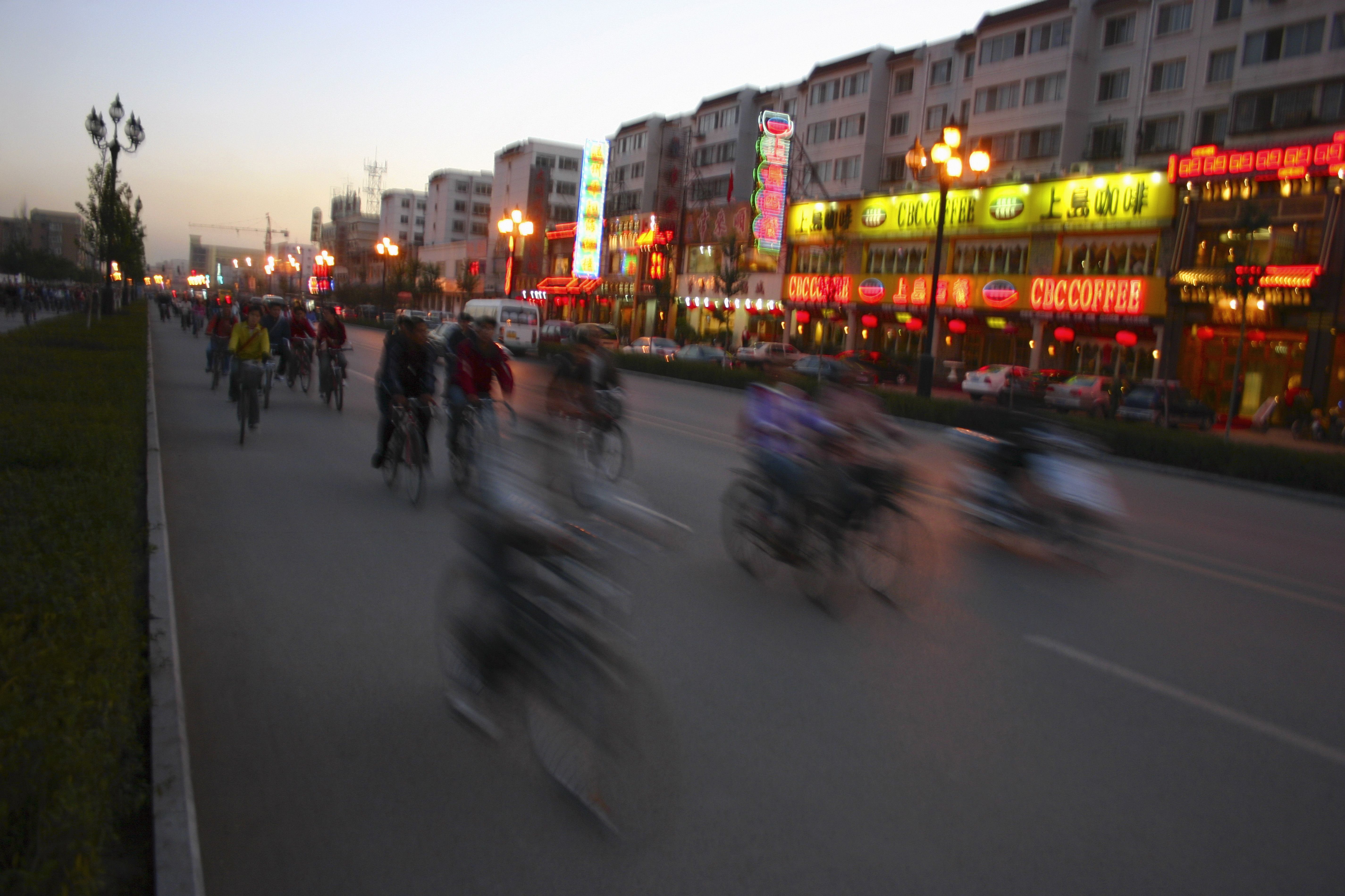 Spostamenti in bicicletta in una via di Hangzhou/Icp