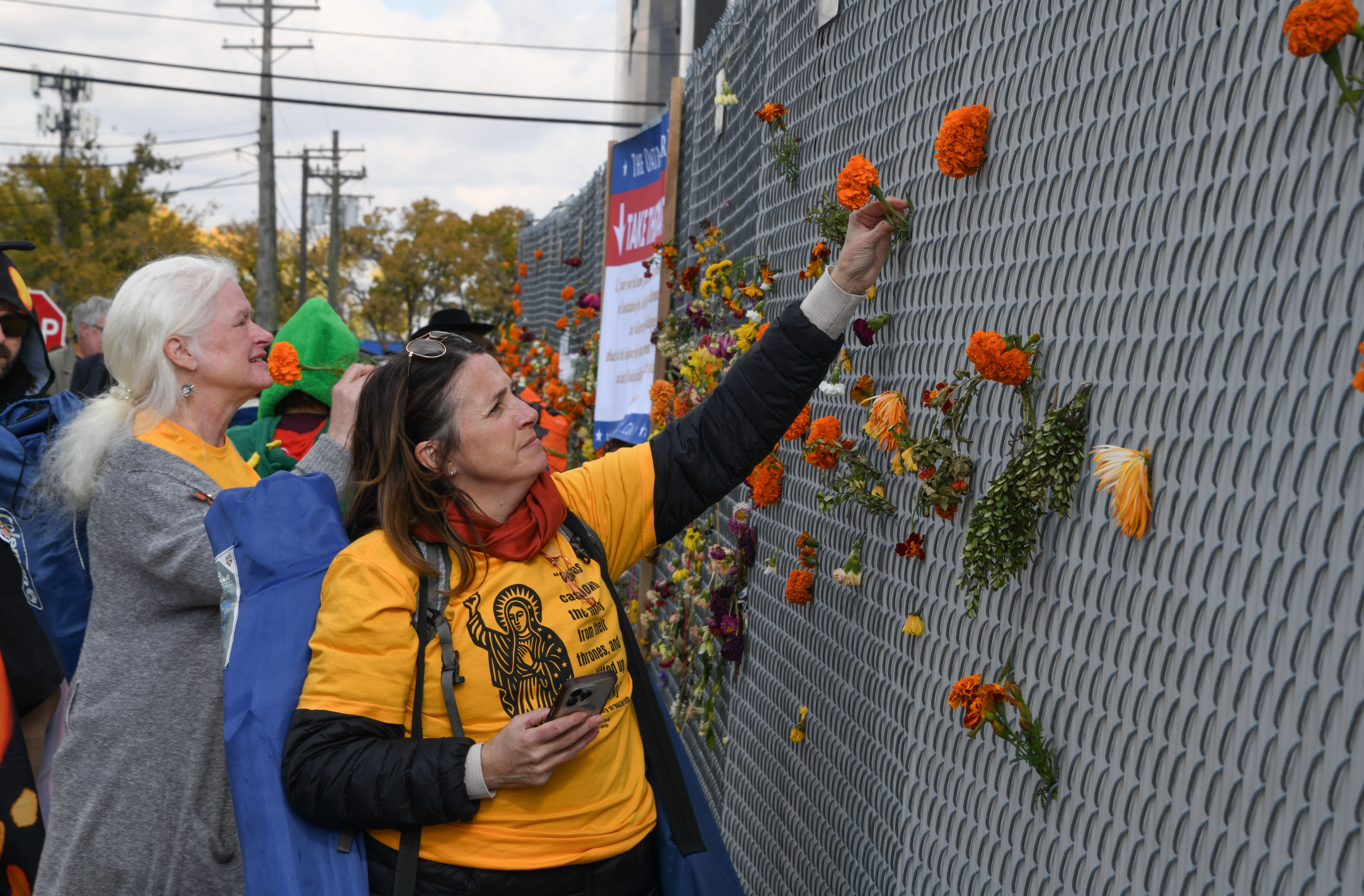 Cattolici di Chicago mettono fiori sulla grata di protezione del centro di detenzione di Broadview, 1 novembre 2025 - (Deb Winarski)
