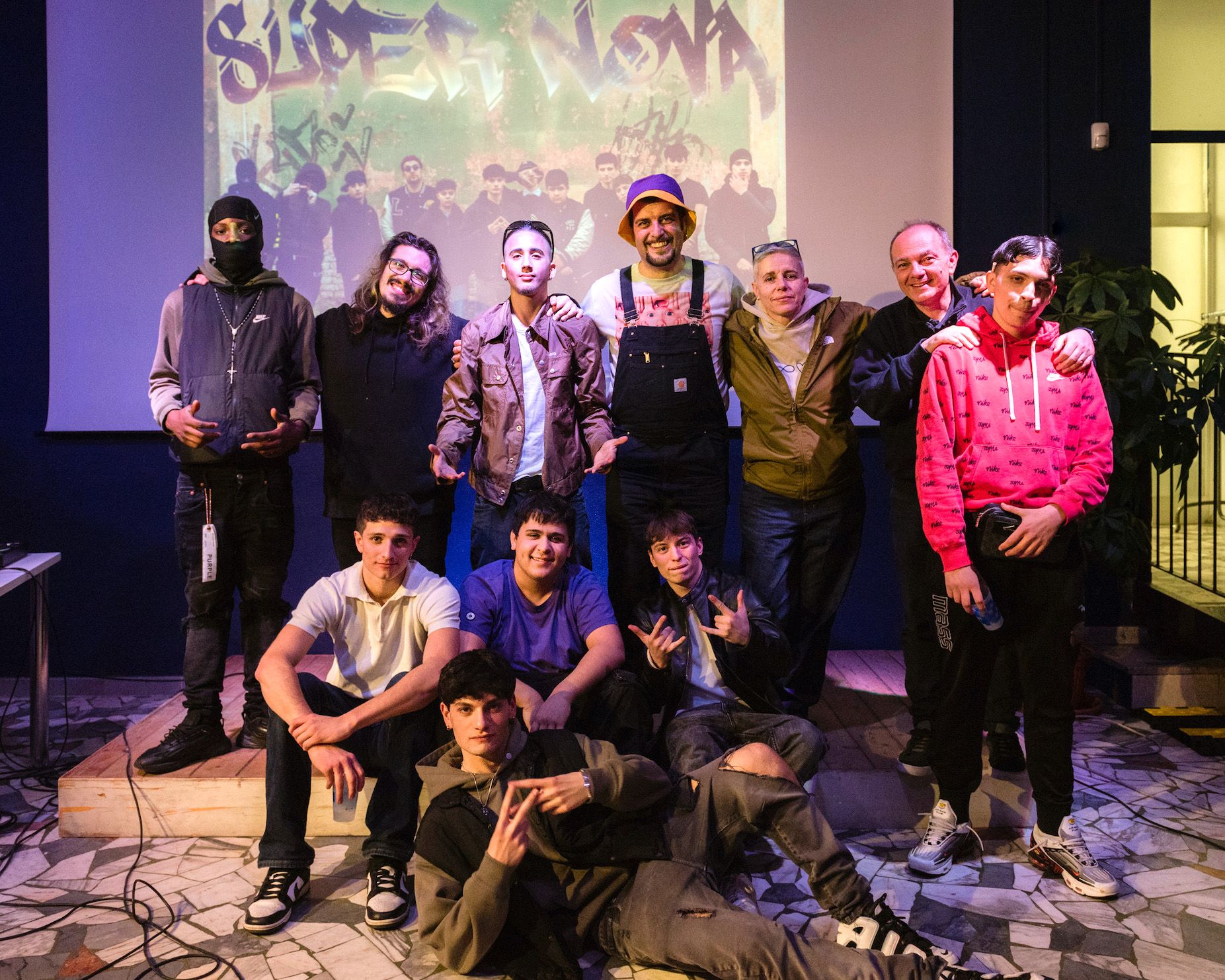 Il prof Passalacqua (in salopette) coi suoi ragazzi, don Claudio Burgio e la produttrice Paola Zukar 