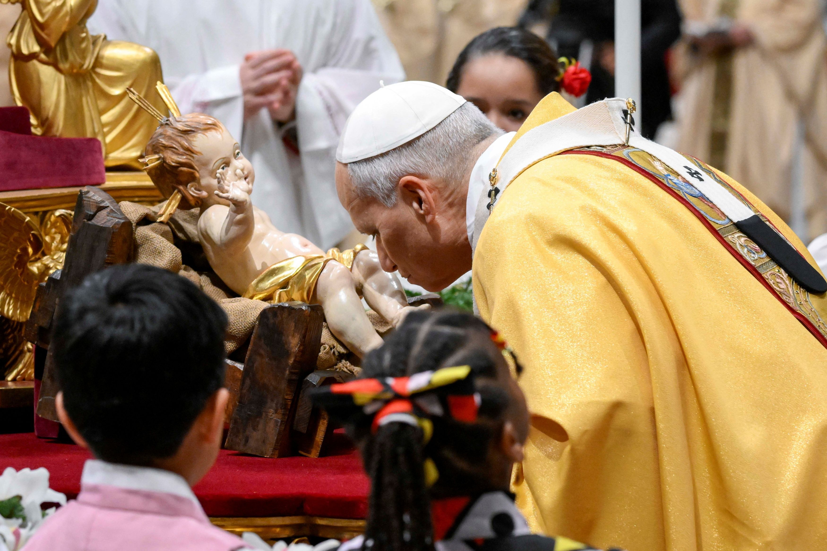 Leone XIV bacia il Bambinello durante la Messa della notte di Natale nella Basilica di San Pietro / REUTERS