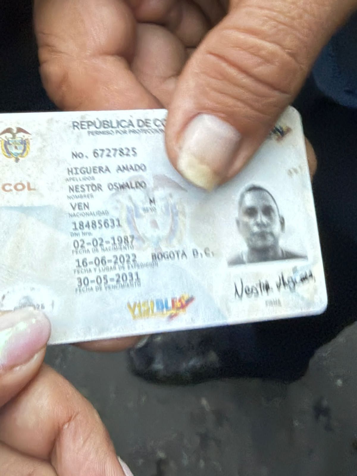 Una madre mostra il documento di suo figlio, detenuto a Caracas