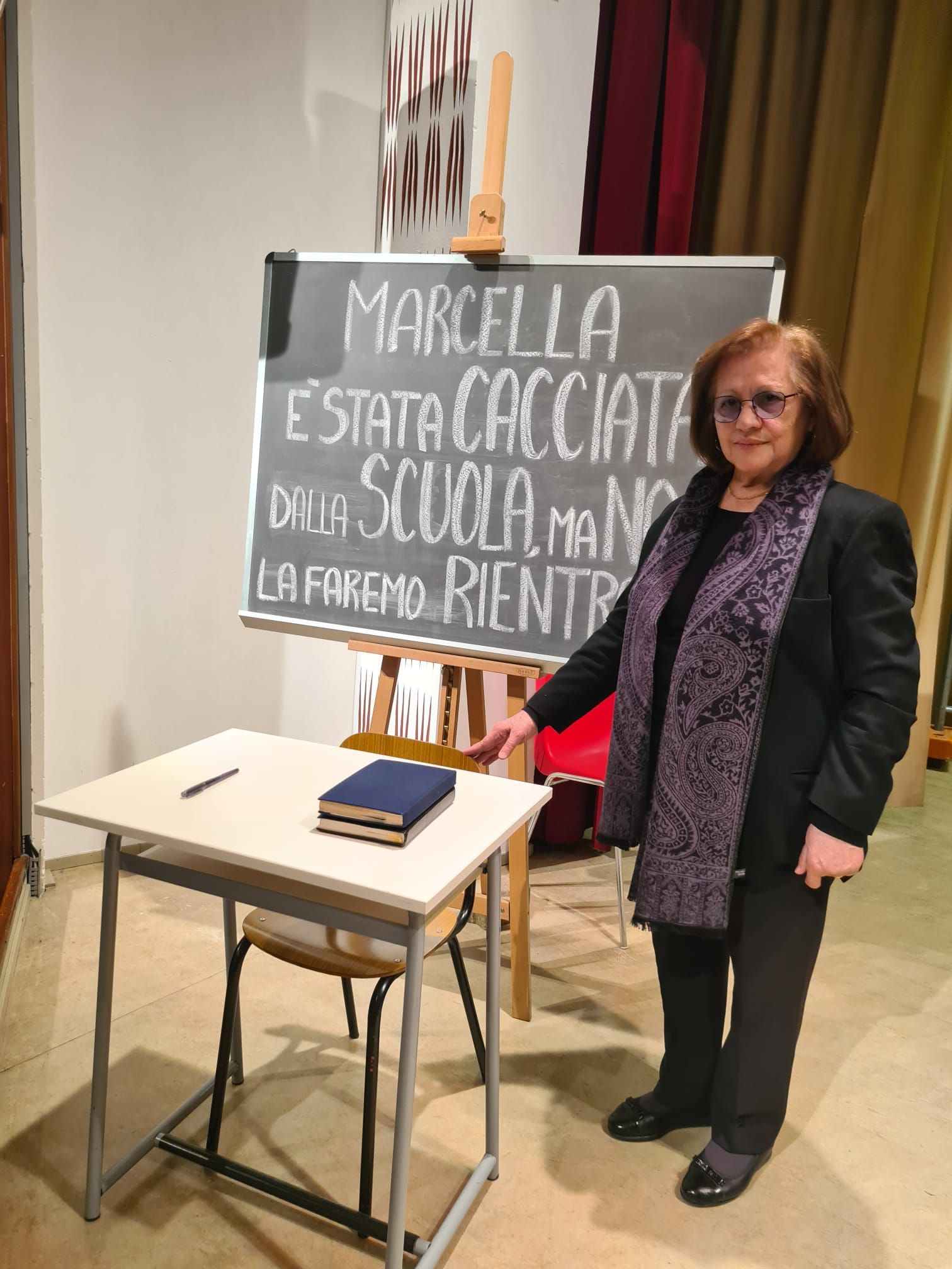Il banco di Marcella all'Istituto Barbara Melzi e, accanto, la madre della giovane vittima di mafia, Marisa Fiorani. Sulla lavagna la scritta: «Marcella è stata cacciata dalla scuola, ma noi la faremo rientrare»