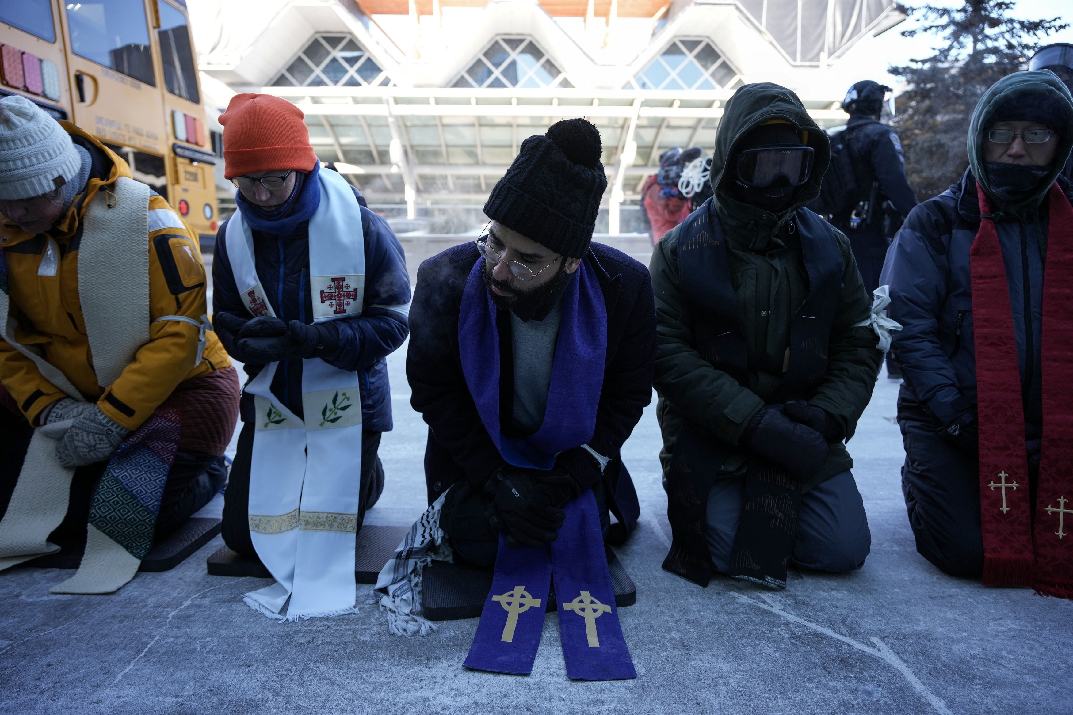Religiosi cristiani in ginocchio per protestare contro i raid anti immigrati dell'Ice .  REUTERS/Tim Evans