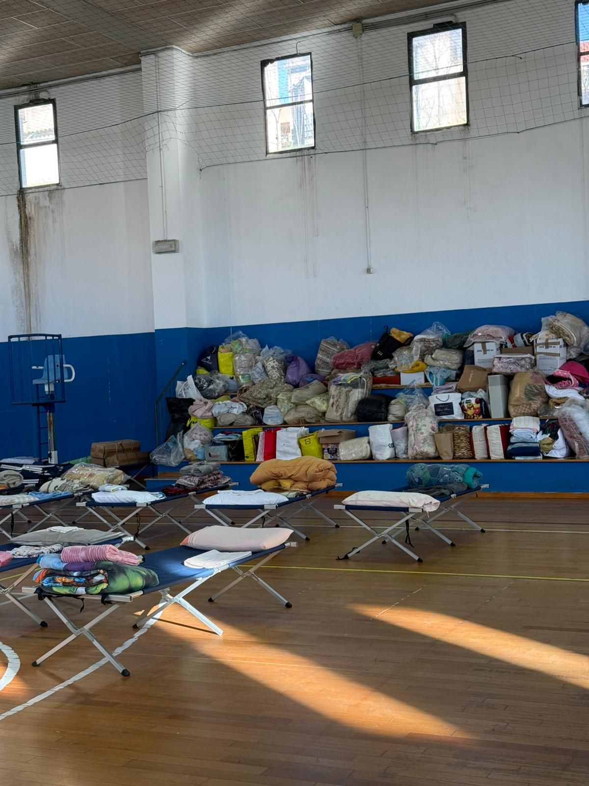 Le brandine allestite in una palestra e gli aiuti raccolti dalla Protezione civile