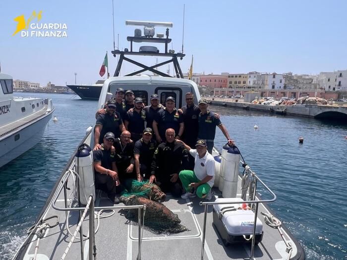 I finanzieri con alcune delle anfore ritrovate / Guardia di finanza