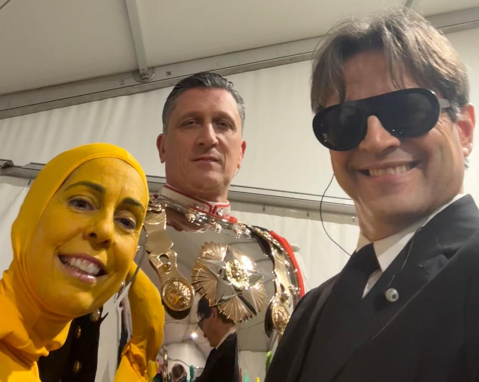 La coppia dietro le quinte con un altro figurante