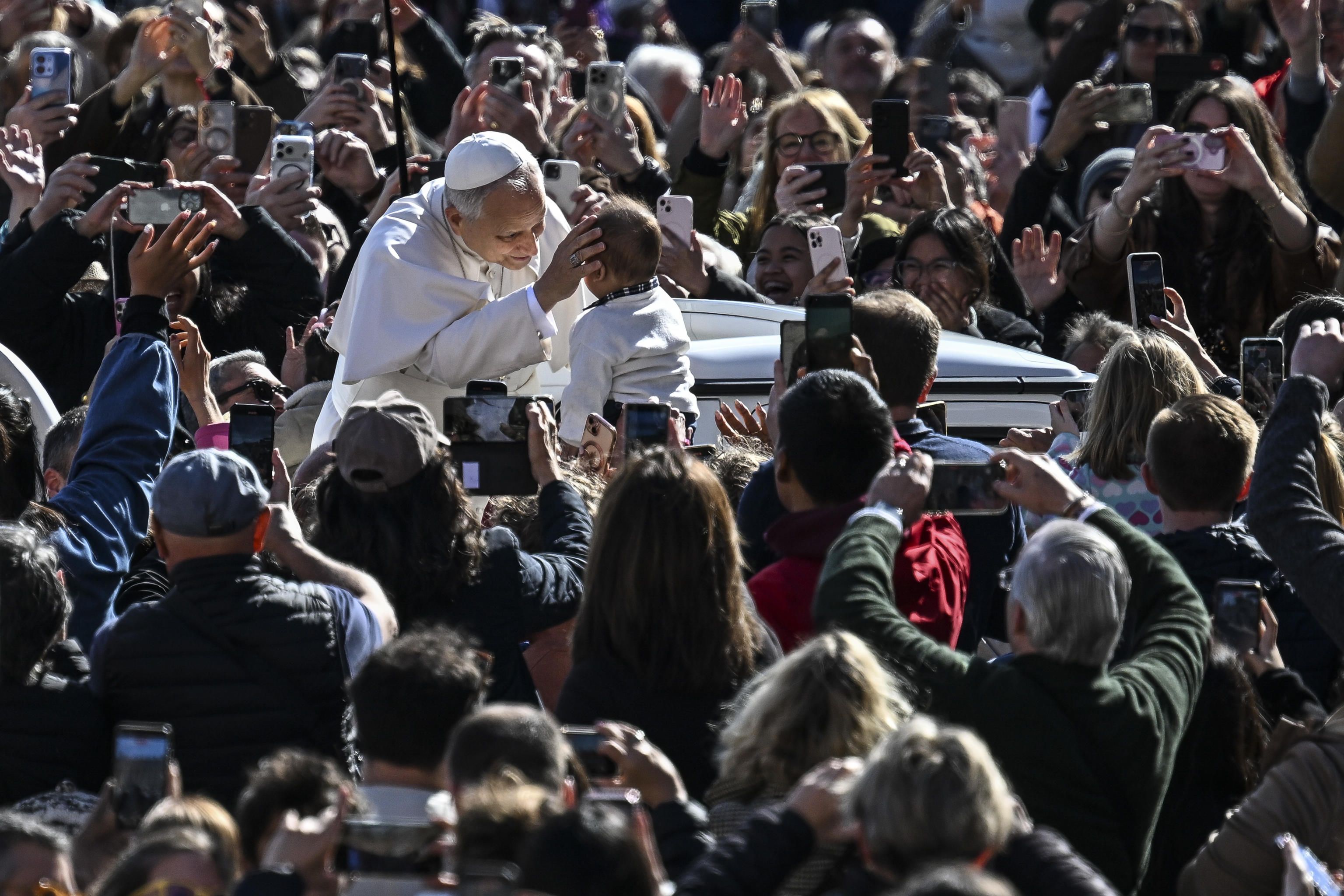 Leone XIV benedice un bambino prima dell'udienza generale in piazza San Pietro, 18 marzo 2026 - (ANSA)