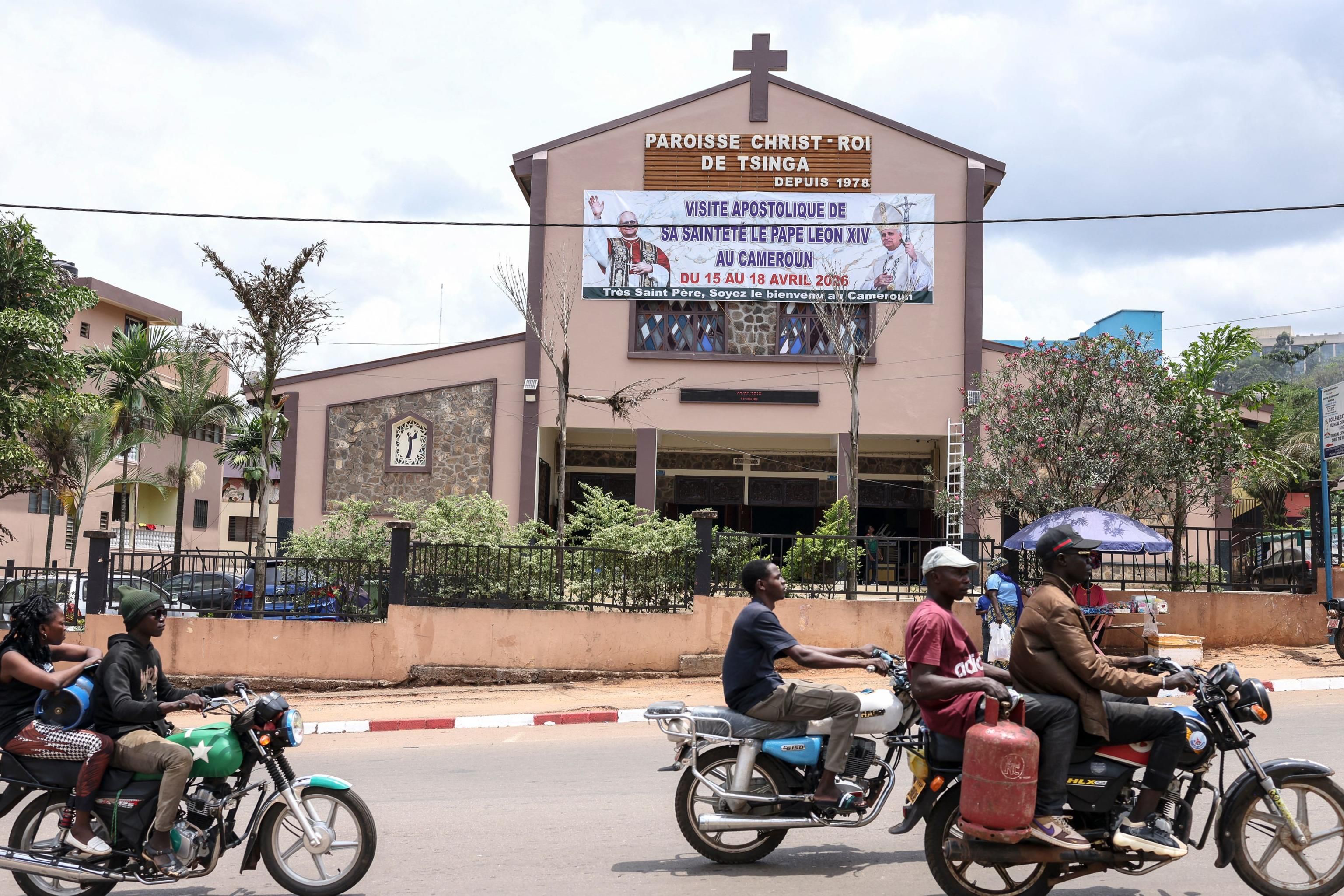 Lo striscione con il volto di papa Leone XIV che annuncia da una chiesa di Yaounde la visita del Pontefice in Camerun / AFP
