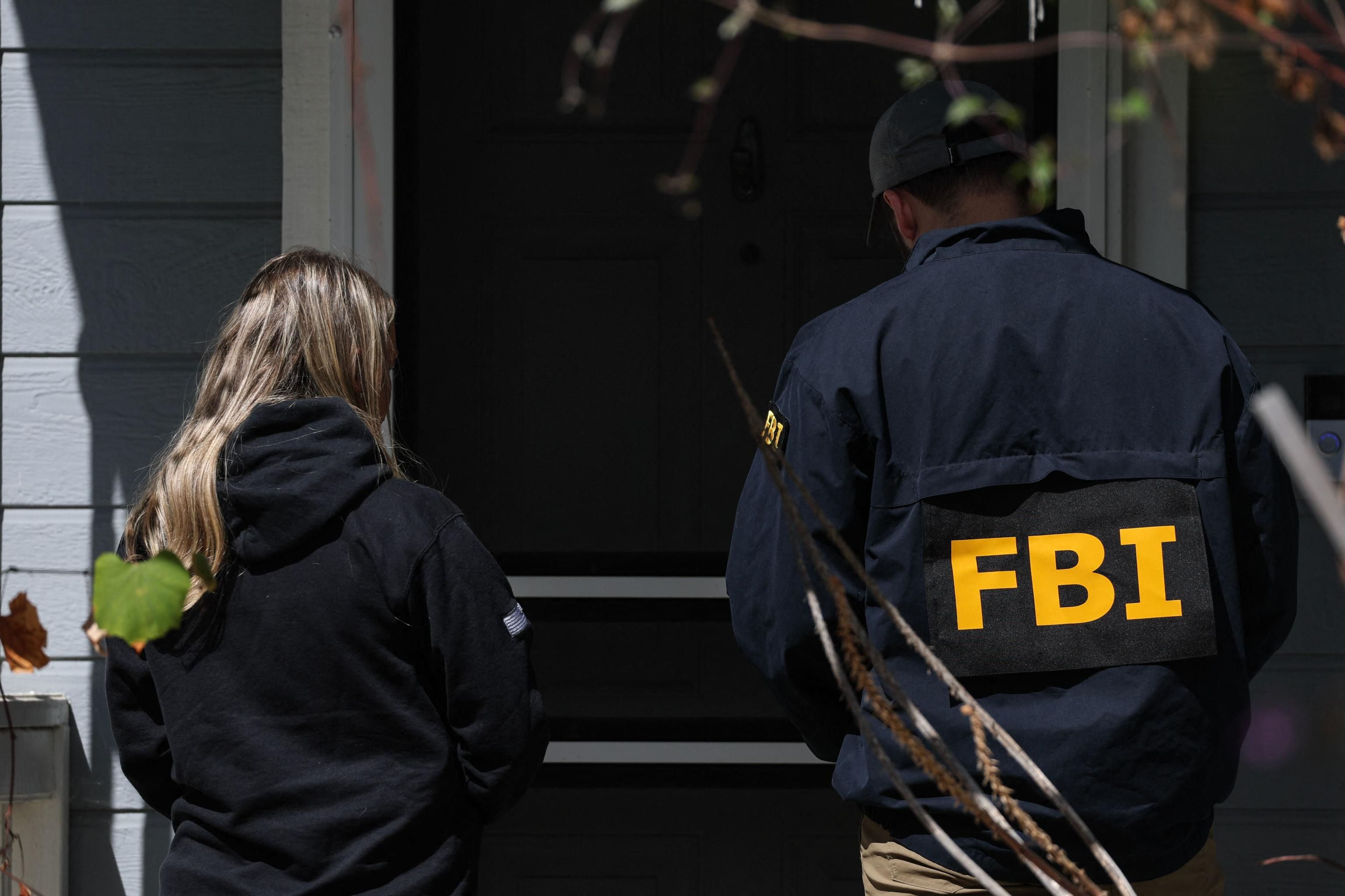 Agenti dell'Fbi alla porta di casa dell'attentatore di Trump, a Terrance, in California / AFP