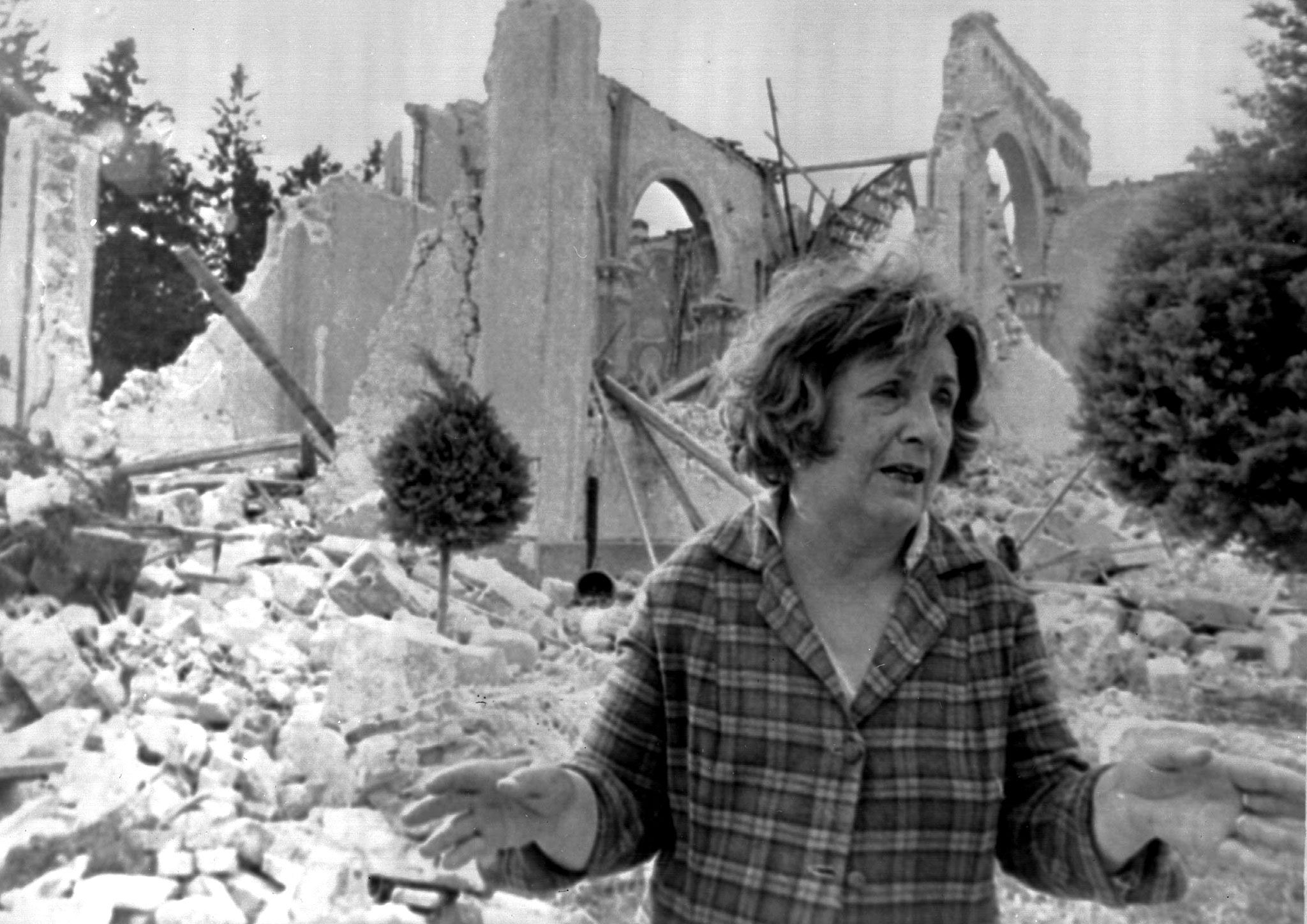 Una donna davanti alle macerie della propria abitazione / Esercito italiano